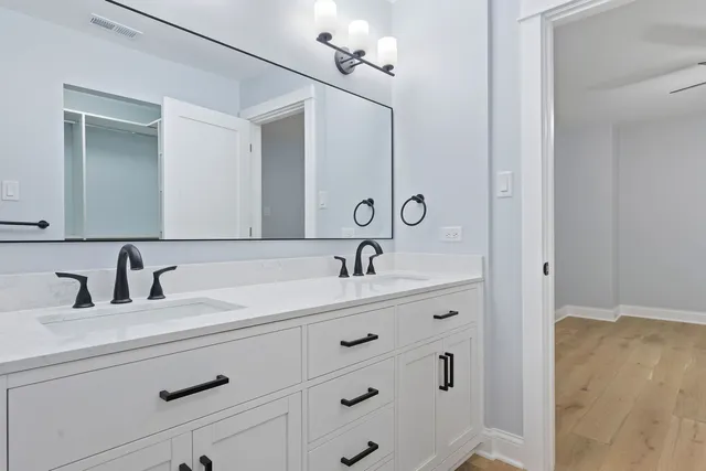 a bathroom with a double vanity sink and a mirror