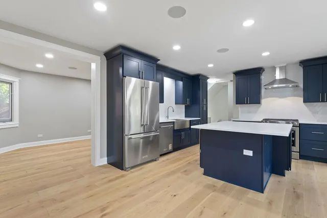 a kitchen with stainless steel appliances granite countertop a refrigerator and a stove