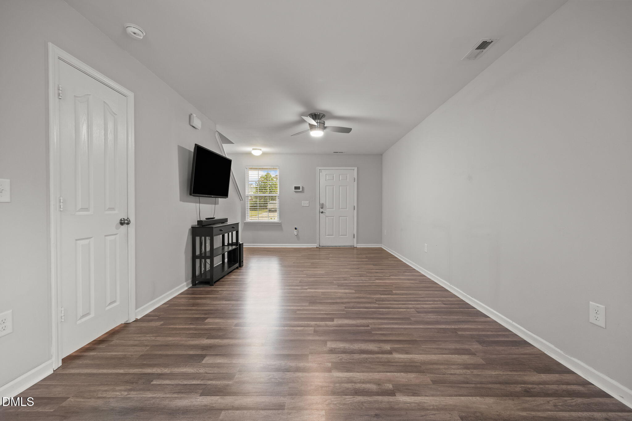 45 Crane Way Bunnlevel, NC 28323 - Photo 7 of 35 a view of a livingroom with a flat screen tv wooden floor and a ceiling fan