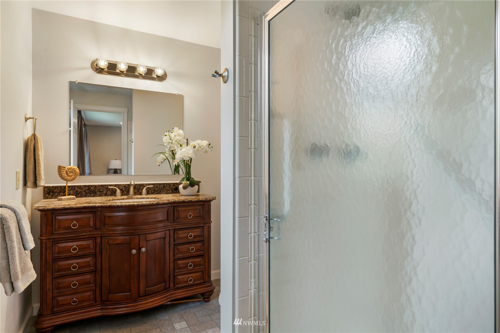 20104 103rd Place Northeast Bothell, WA 98011 - Photo 29 of 40 a bathroom with a granite countertop sink a mirror and a shower