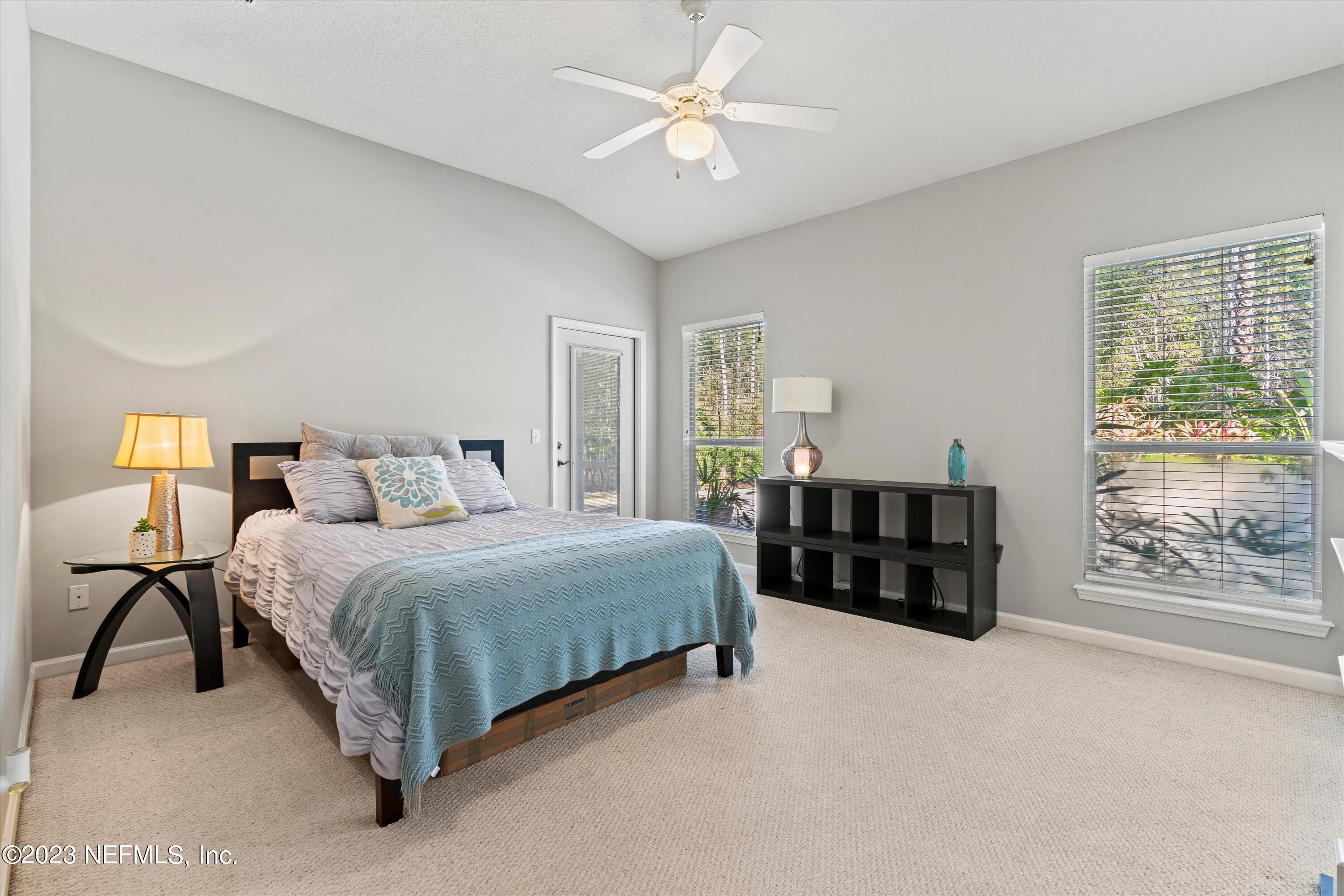 618 Racoon Court St. Johns, FL 32259 - Photo 13 of 61 a bedroom with a bed two lamps and a chandelier