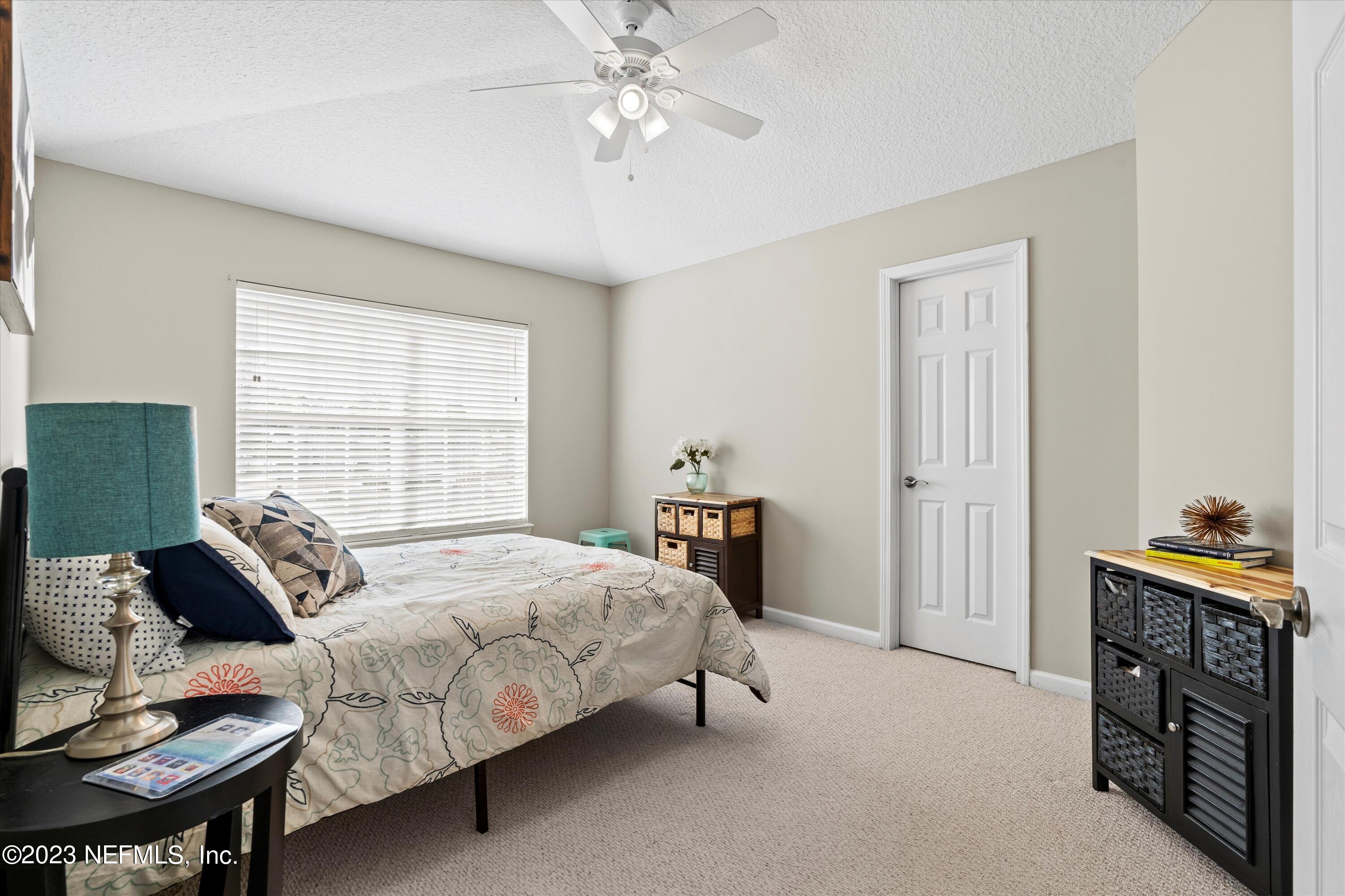 618 Racoon Court St. Johns, FL 32259 - Photo 25 of 61 a bedroom with a bed and a chandelier