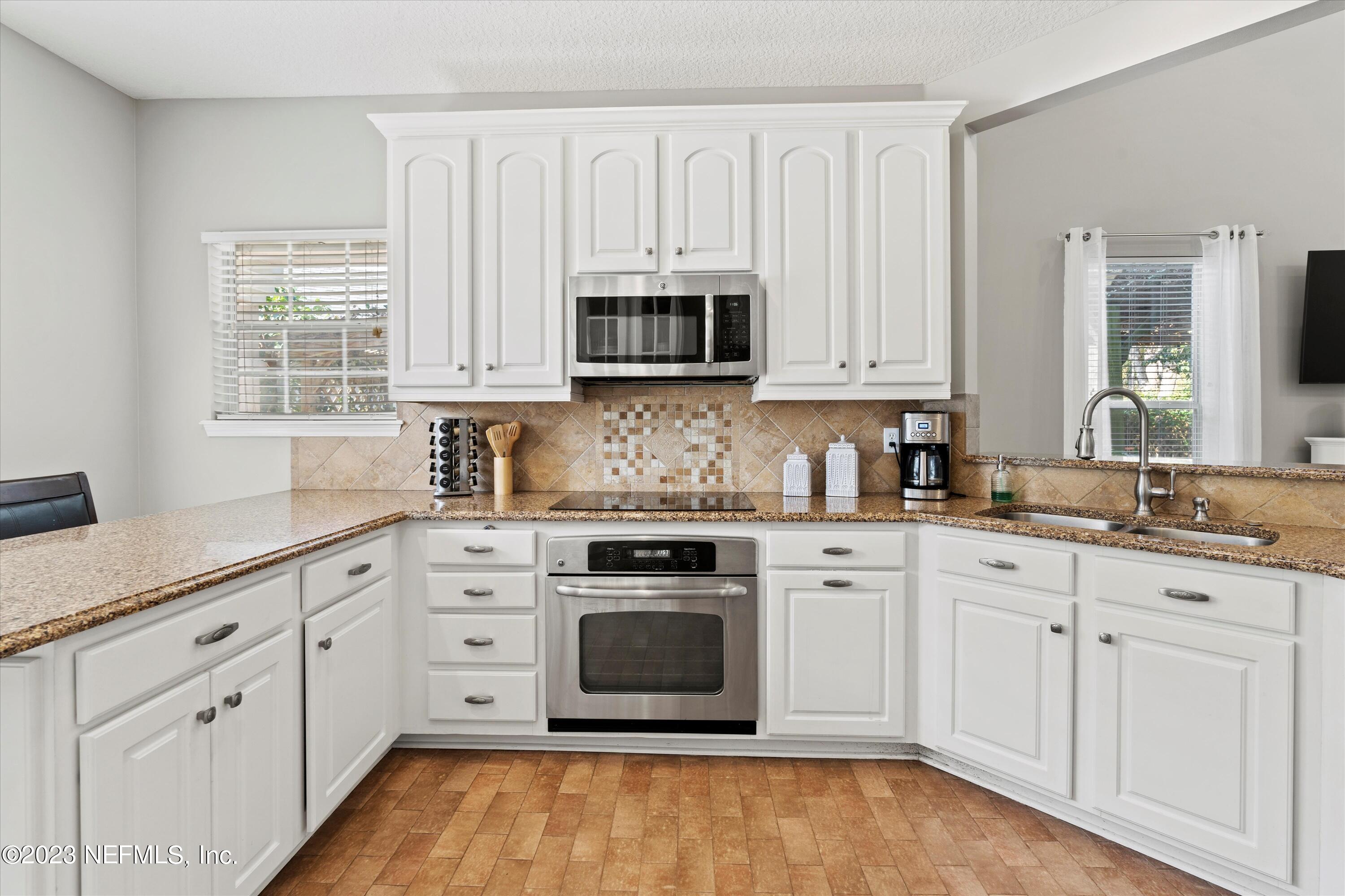 618 Racoon Court St. Johns, FL 32259 - Photo 10 of 61 a kitchen with white cabinets and appliances