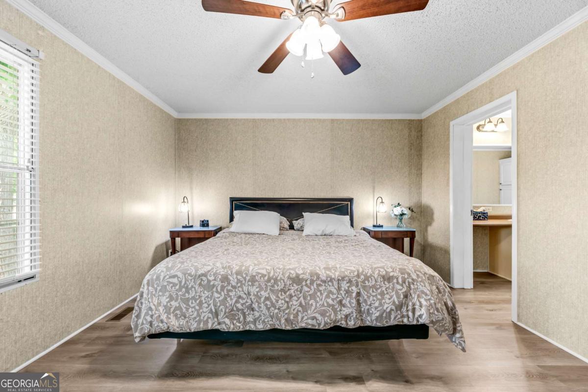 194 Phillips Road Eatonton, GA 31024 - Photo 20 of 57 a bedroom with a bed and a chandelier