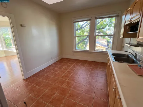 a view of a kitchen with a sink wooden cabinets and a window