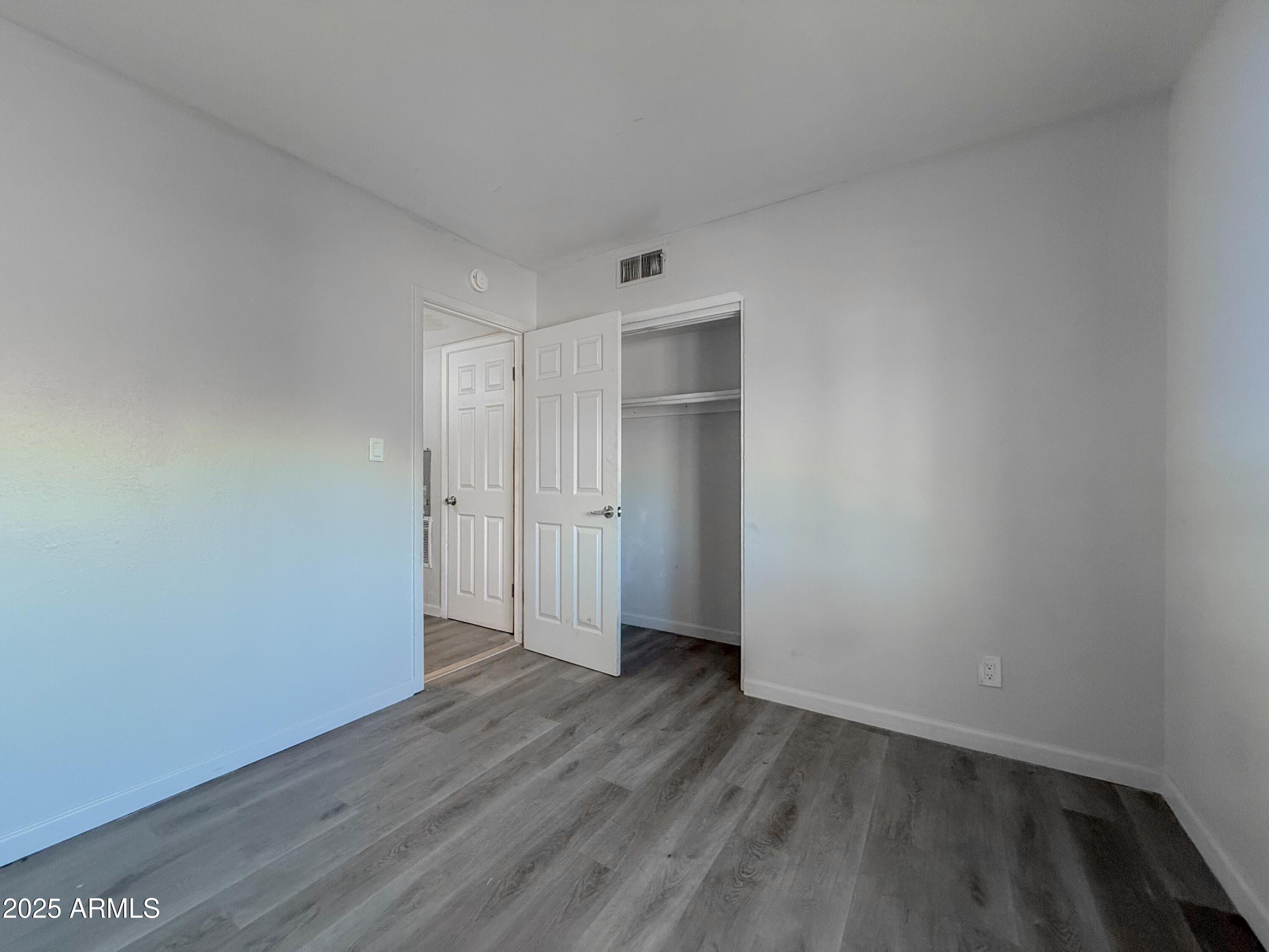 1703 West Mountain View Road, Unit 13 Phoenix, AZ 85021 - Photo 7 of 12 a view of an empty room with wooden floor