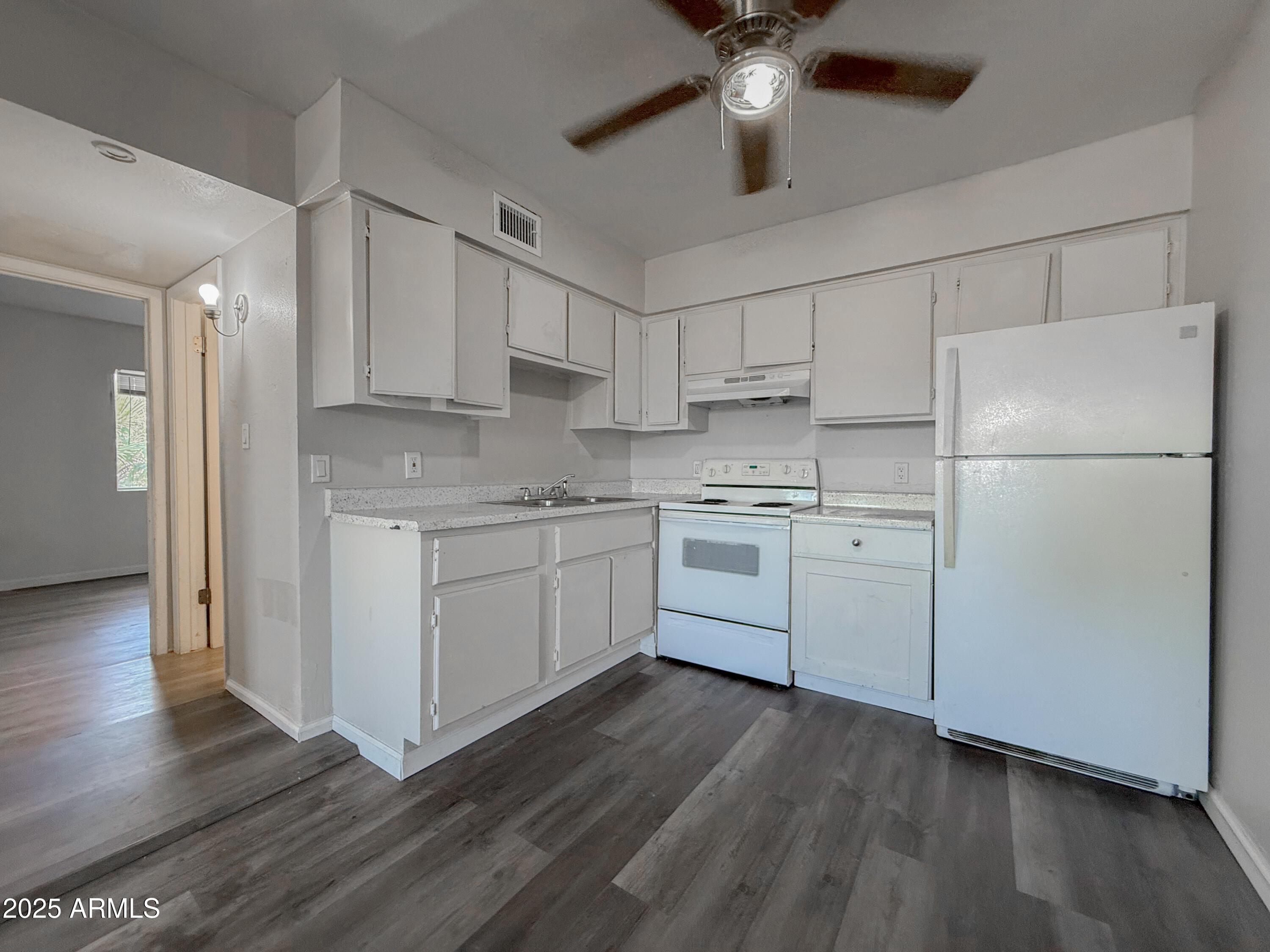 1703 West Mountain View Road, Unit 13 Phoenix, AZ 85021 - Photo 8 of 12 a kitchen with a refrigerator a sink and cabinets