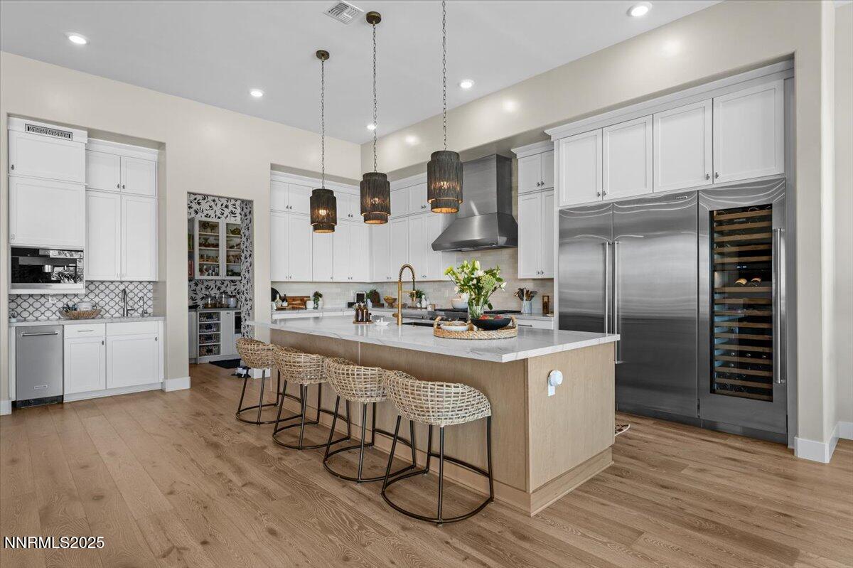1593 River Hill Way Reno, NV 89523 - Photo 5 of 63 a kitchen with stainless steel appliances kitchen island granite countertop a stove a sink a refrigerator and white cabinets with wooden floor