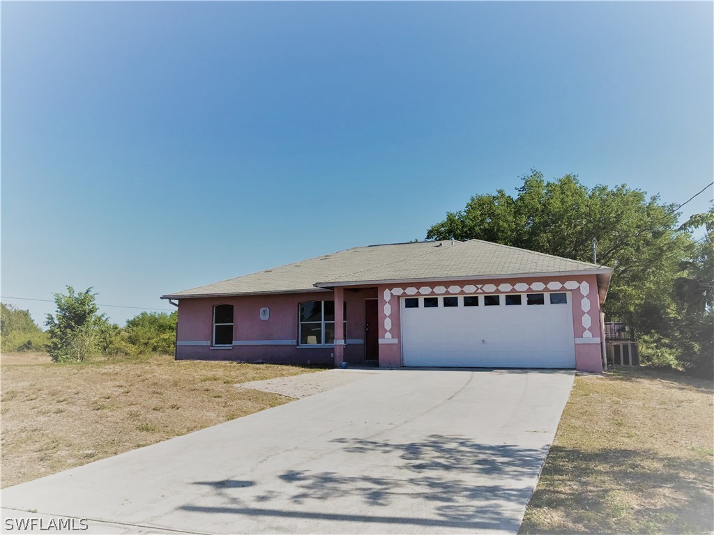4458 28th Street Southwest Lehigh Acres, FL 33973 - Photo 1 of 22 a front view of a house with a yard