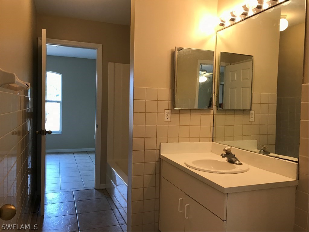4458 28th Street Southwest Lehigh Acres, FL 33973 - Photo 17 of 22 a bathroom with a sink and a mirror