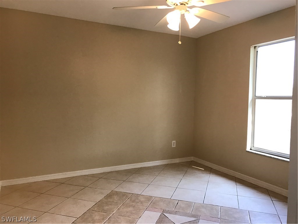 4458 28th Street Southwest Lehigh Acres, FL 33973 - Photo 19 of 22 an empty room with a chandelier fan and window