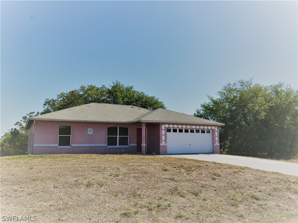4458 28th Street Southwest Lehigh Acres, FL 33973 - Photo 2 of 22 a front view of a house with a yard