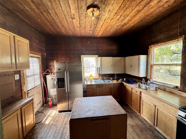 a kitchen with stainless steel appliances granite countertop sink stove refrigerator and cabinets