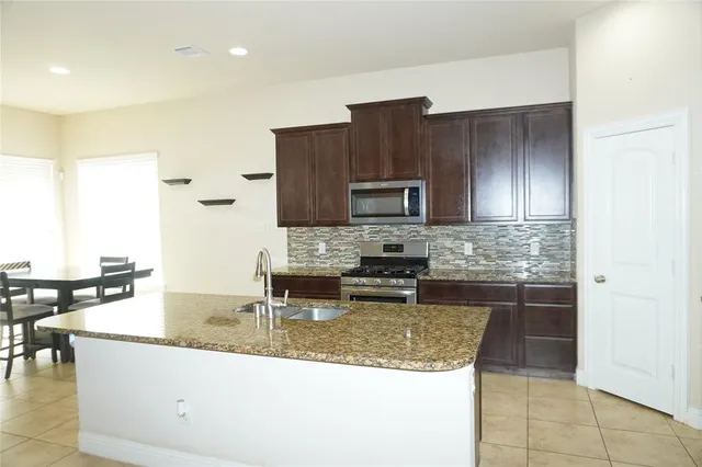 a kitchen with stainless steel appliances granite countertop a sink and a stove