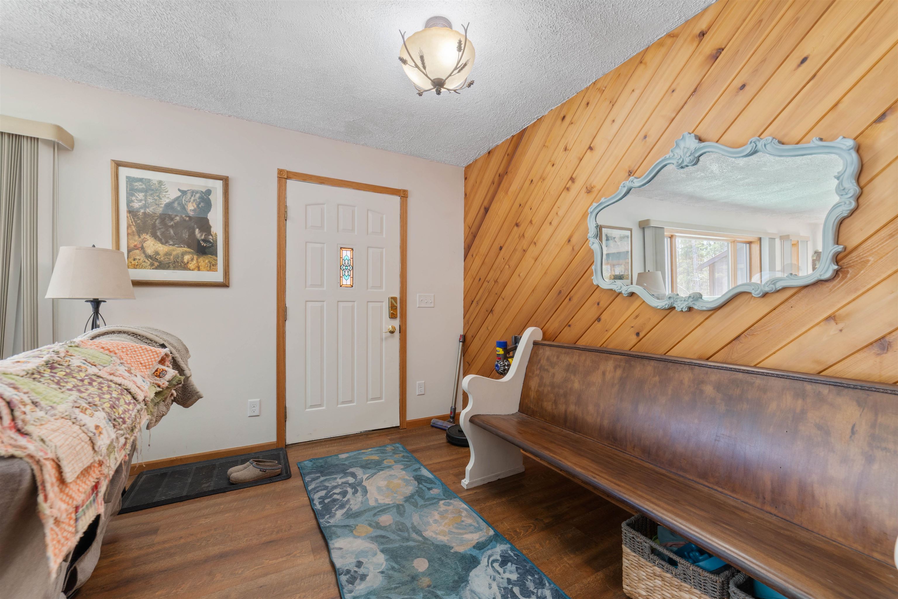 6960 South County Rd B Foxboro, WI 54836 - Photo 14 of 28 Entrance foyer with wooden walls, wood finished floors, baseboards, and a textured ceiling