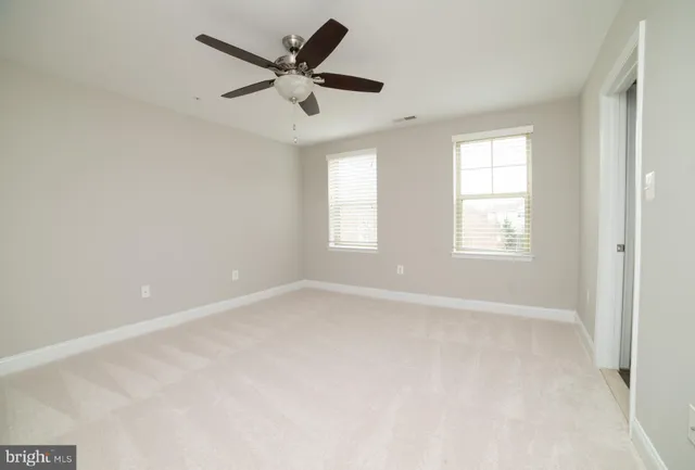 an empty room with a window and a fan