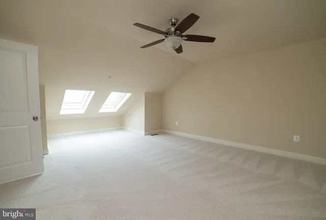 an empty room with windows and fan view