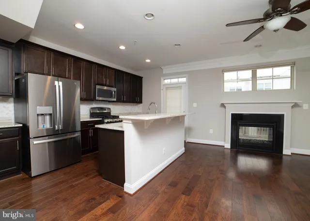 a kitchen with wooden floors and stainless steel appliances