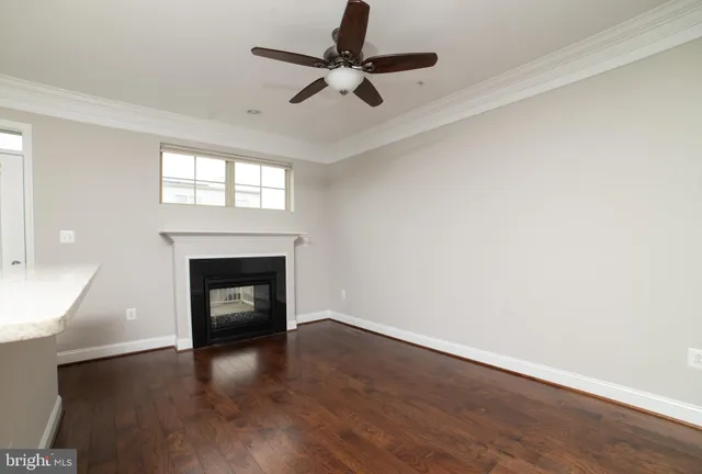 a view of empty room with wooden floor fireplace and a window