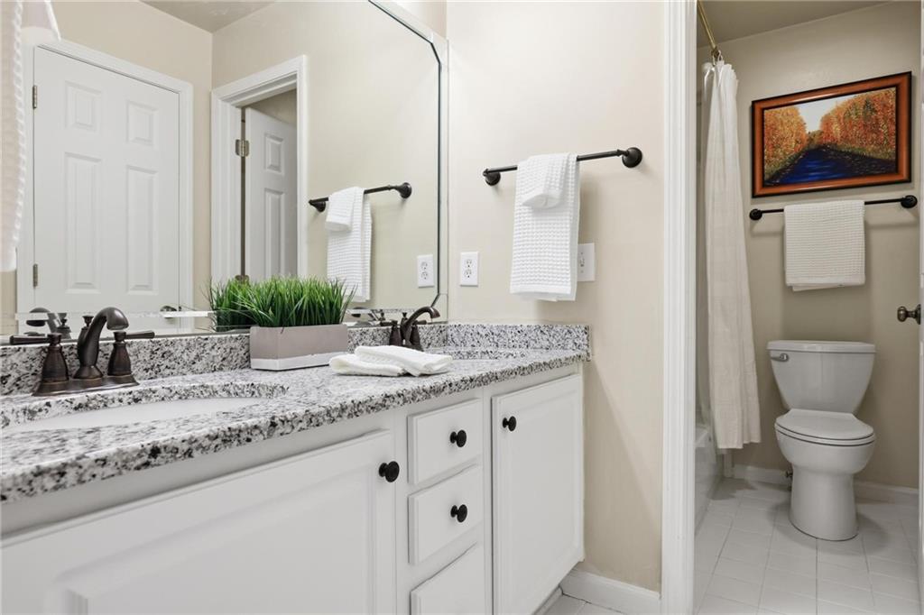5249 Magnolia Walk Circle Atlanta, GA 30338 - Photo 25 of 30 a bathroom with a granite countertop sink a toilet and a mirror