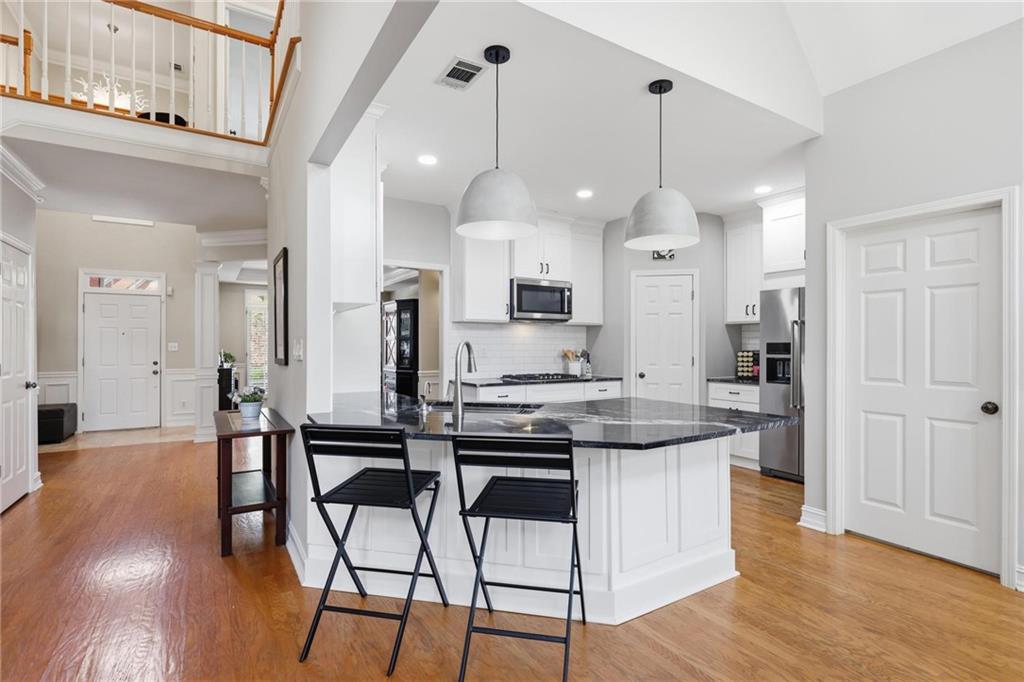 5249 Magnolia Walk Circle Atlanta, GA 30338 - Photo 7 of 30 a kitchen with stainless steel appliances a dining table chairs stove and cabinets