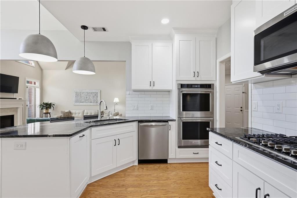5249 Magnolia Walk Circle Atlanta, GA 30338 - Photo 10 of 30 a kitchen with stainless steel appliances a stove a sink and white cabinets