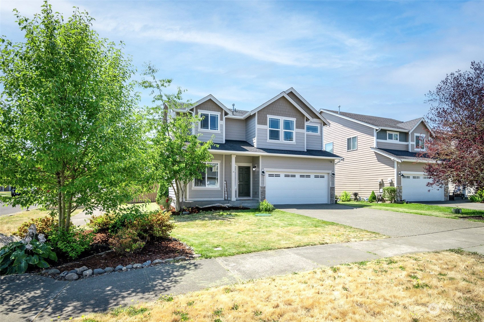 14453 98th Way Southeast Yelm, WA 98597 - Photo 2 of 23 a front view of a house with a yard and garage