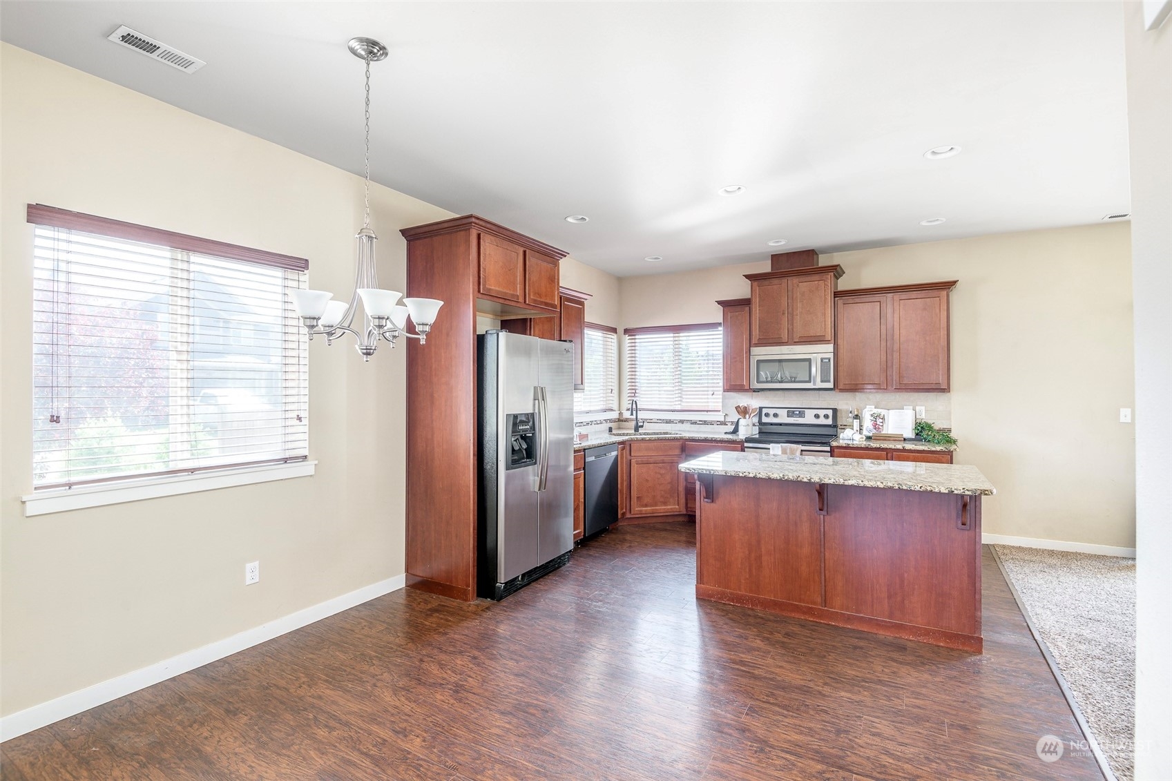 14453 98th Way Southeast Yelm, WA 98597 - Photo 5 of 23 a kitchen with stainless steel appliances granite countertop a refrigerator a sink dishwasher a stove and white countertops with wooden floor