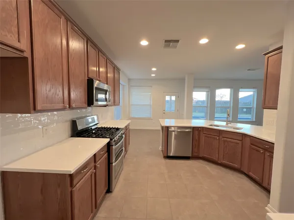 a large kitchen with stainless steel appliances lots of counter top space
