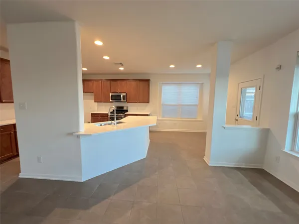 a open kitchen with kitchen island a sink a stove and a refrigerator