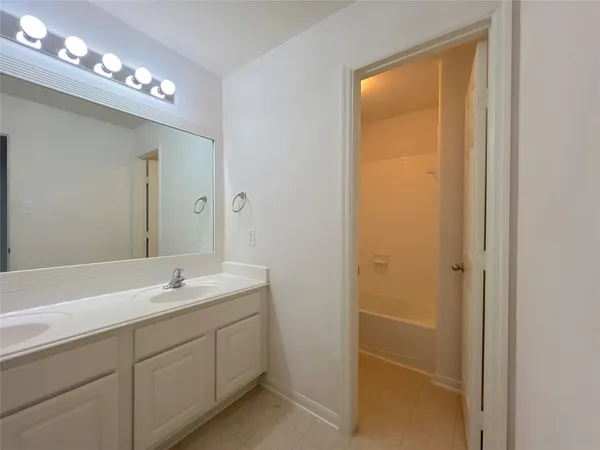 a bathroom with a double vanity sink and a mirror