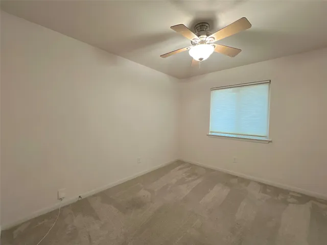 an empty room with closet and ceiling fan