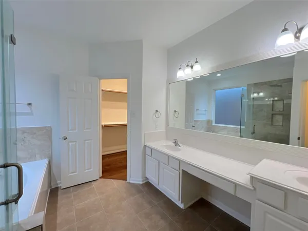 a spacious bathroom with a bathtub sink and mirror