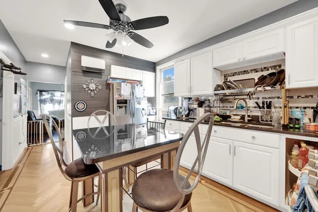 a kitchen with stainless steel appliances granite countertop a sink a stove and chairs