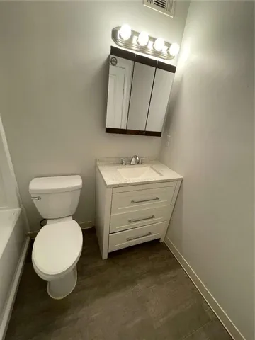 a bathroom with a toilet a sink and mirror