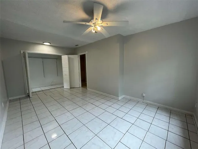 a view of an empty room and a chandelier fan