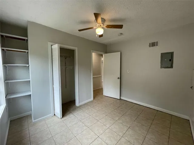 a view of an empty room with a chandelier fan