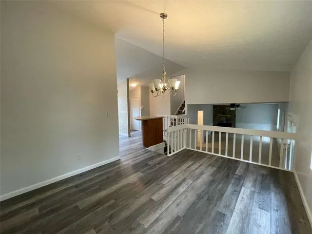 a view of a room with wooden floor and pendant lights