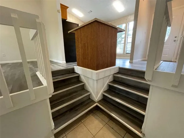 a view of staircase with wooden floor and white walls