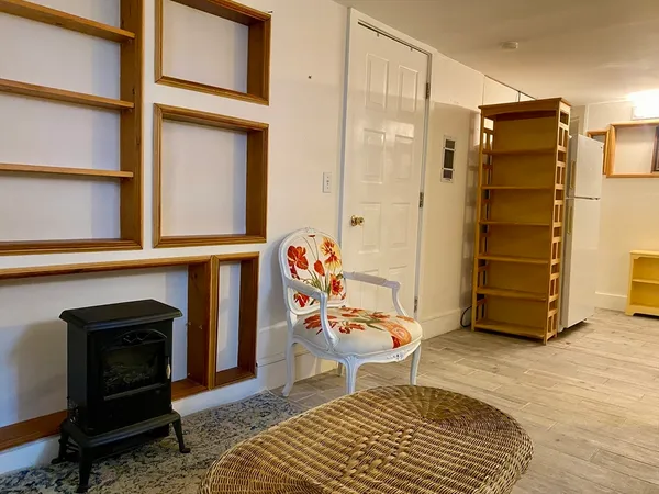 a living room with furniture a fireplace and a walk in closet