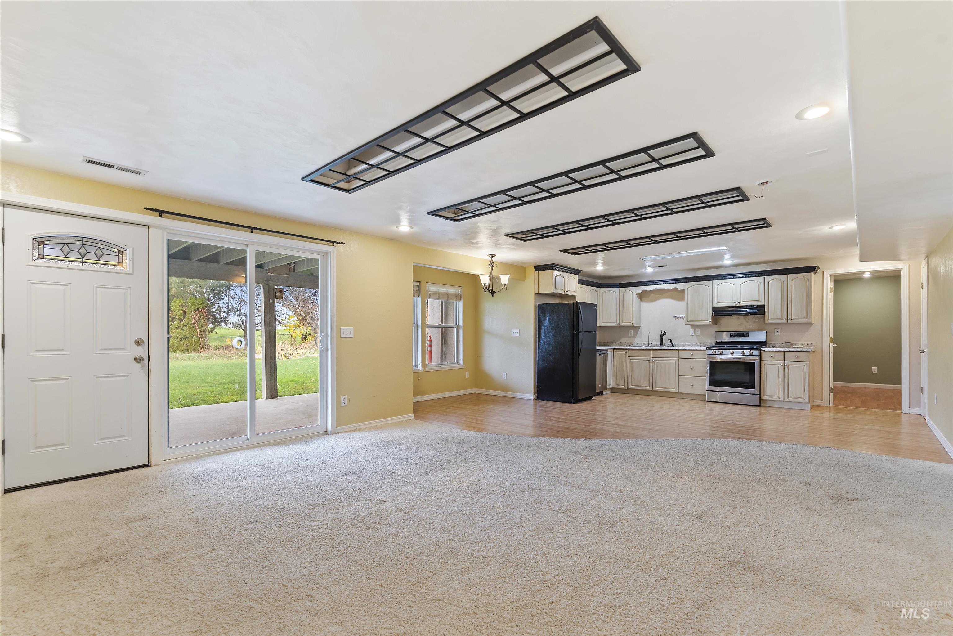 3160 East Springwood Drive Meridian, ID 83642 - Photo 41 of 41 Kitchen with open floor plan, recessed lighting, stainless steel gas range, a chandelier, and freestanding refrigerator