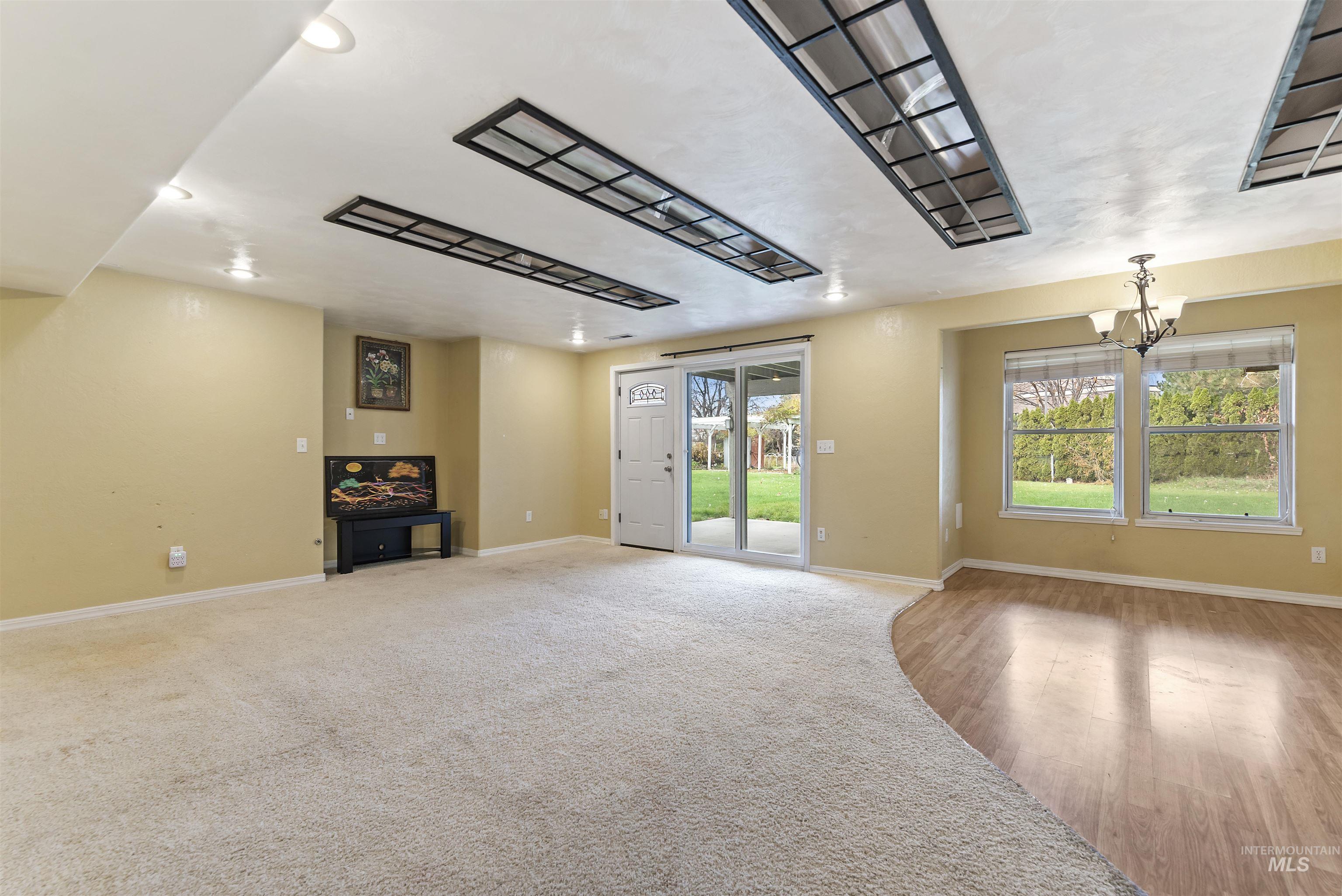3160 East Springwood Drive Meridian, ID 83642 - Photo 11 of 41 Unfurnished living room featuring baseboards and a chandelier