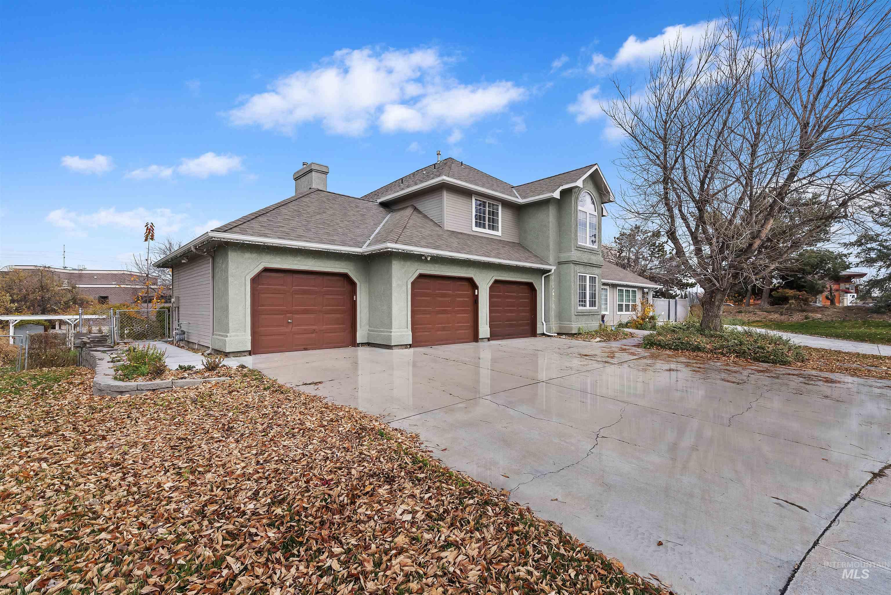 3160 East Springwood Drive Meridian, ID 83642 - Photo 2 of 41 View of front facade with a chimney, driveway, a shingled roof, an attached garage, and stucco siding
