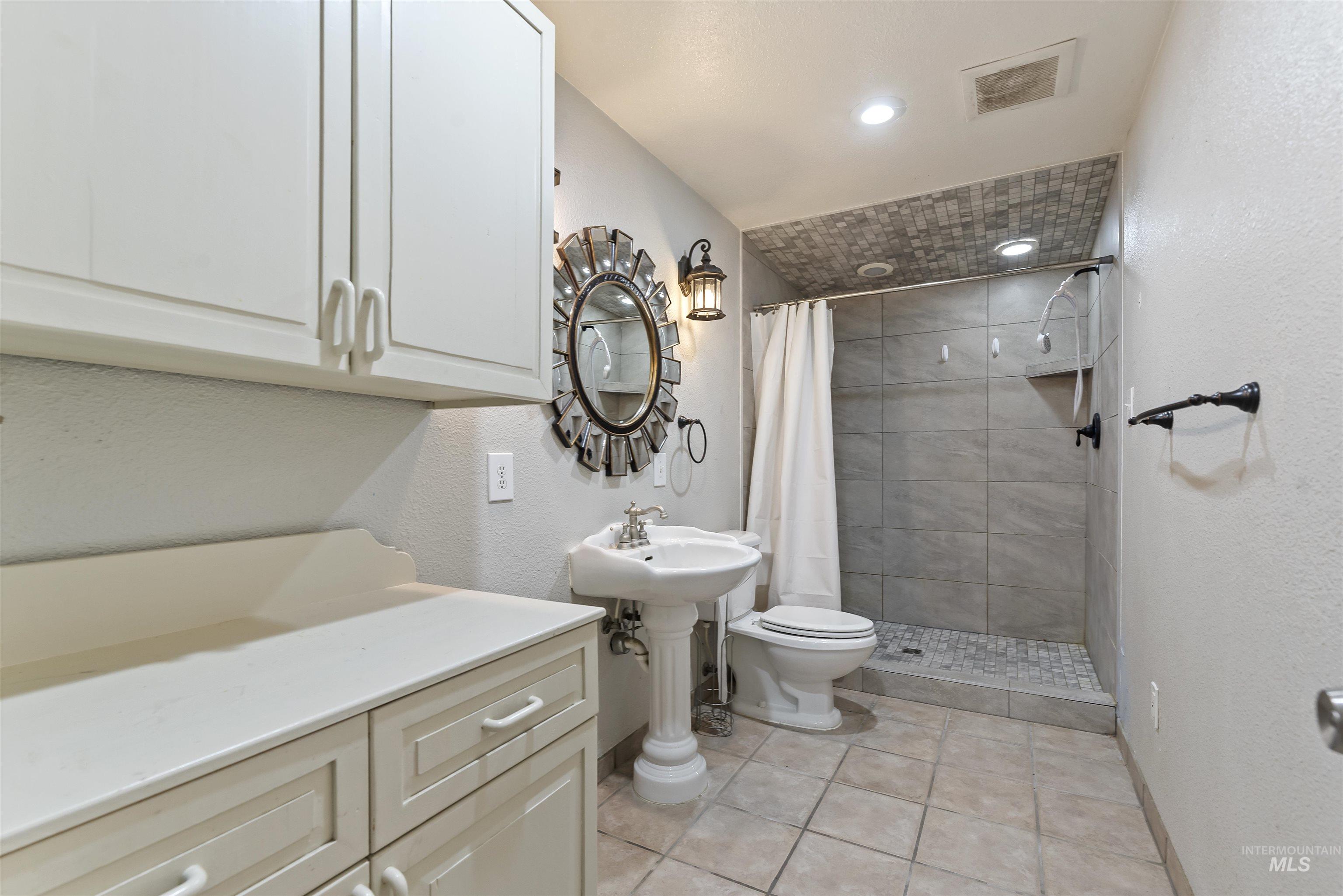 3160 East Springwood Drive Meridian, ID 83642 - Photo 26 of 41 Bathroom featuring a textured wall, a stall shower, light tile patterned floors, and recessed lighting