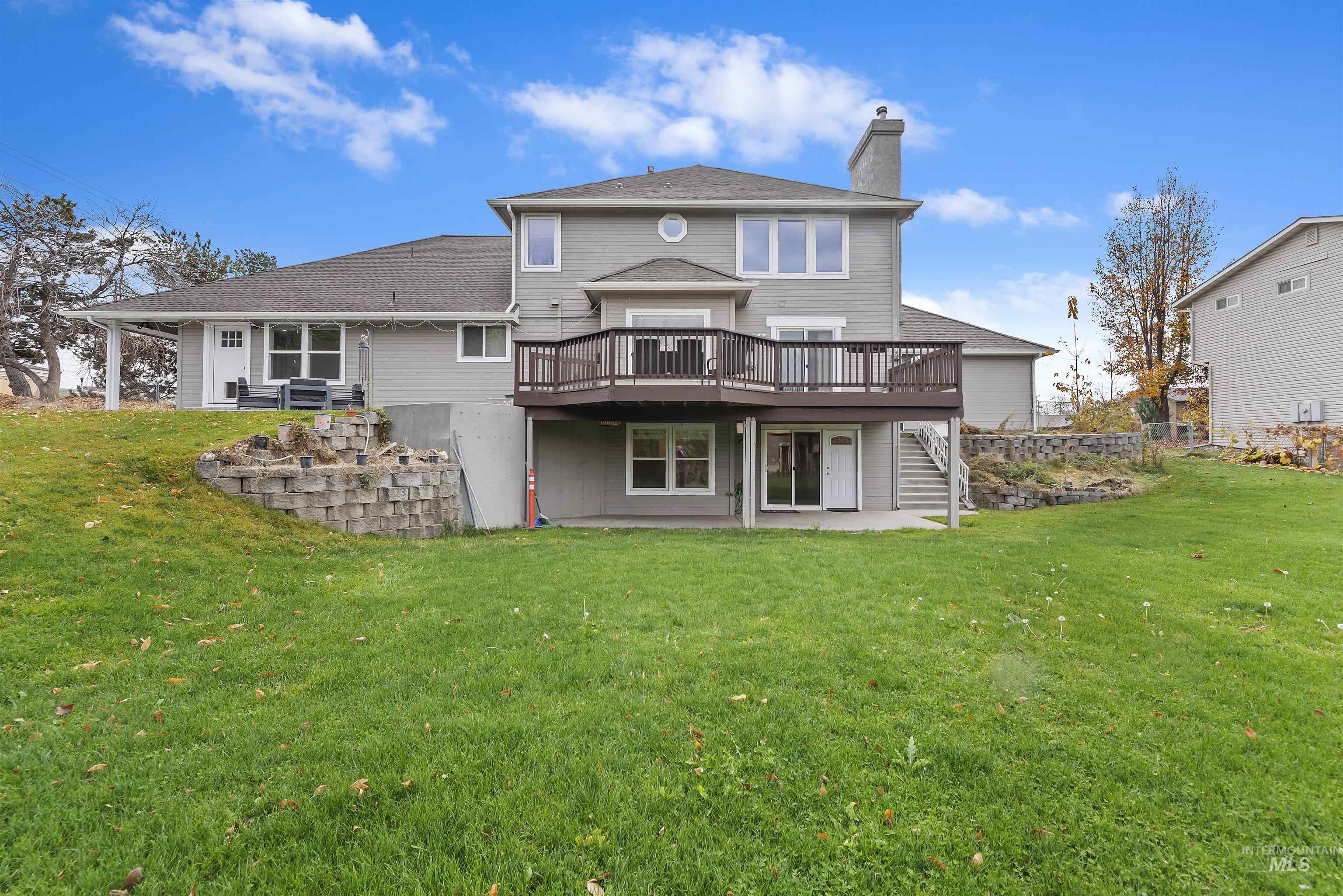 3160 East Springwood Drive Meridian, ID 83642 - Photo 39 of 41 Back of house with a wooden deck, a patio area, a lawn, and a chimney