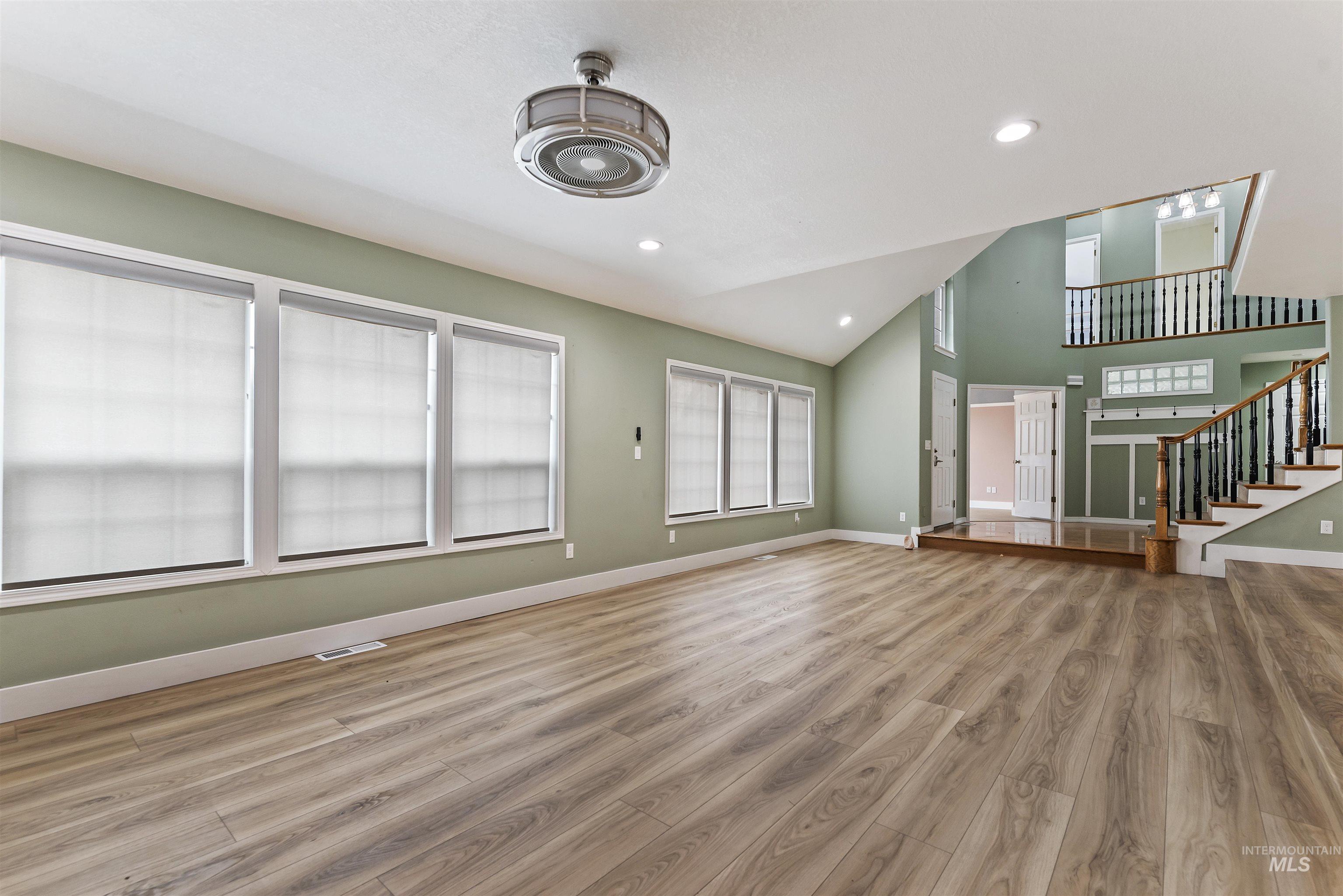 3160 East Springwood Drive Meridian, ID 83642 - Photo 6 of 41 Unfurnished living room featuring stairs, light wood-type flooring, recessed lighting, and high vaulted ceiling