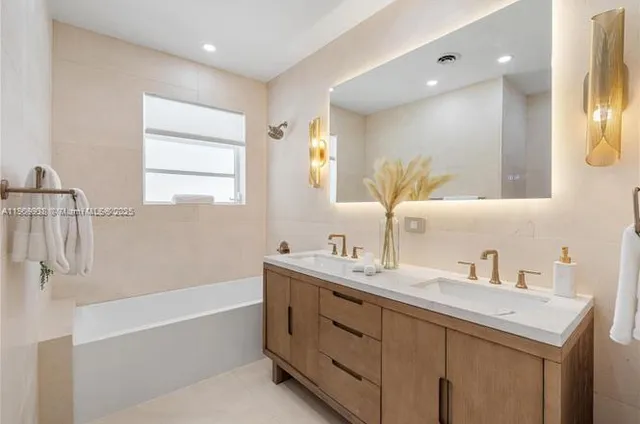 a bathroom with a tub sink and mirror