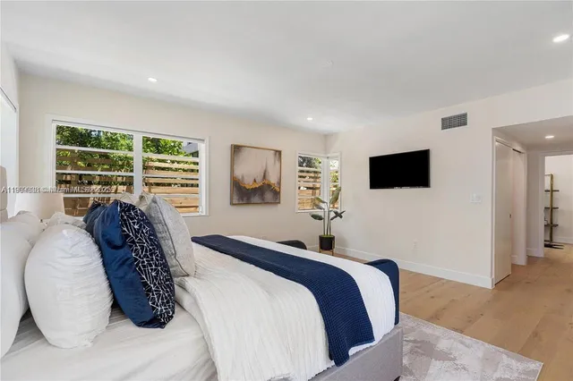 a bedroom with a large bed and a flat screen tv