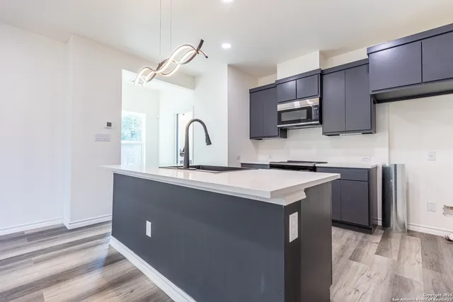 a kitchen with kitchen island a sink appliances and cabinets