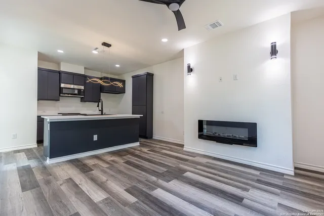 a view of kitchen with a sink wooden cabinet and a refrigerator
